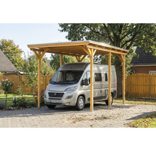 Carport aus Holz mit silbernem Auto auf einem gepflasterten Hof.