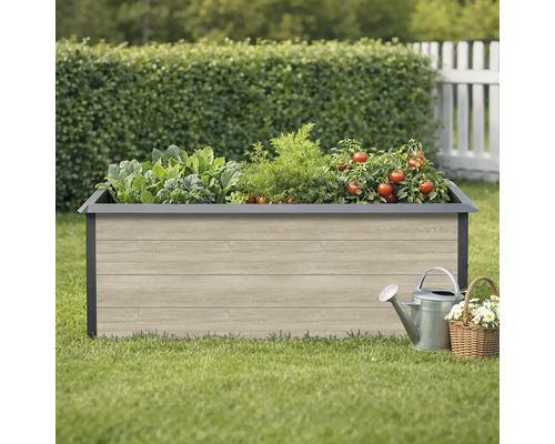 Hochbeet mit Gemüse, Giesskanne und Blumenkorb im Garten