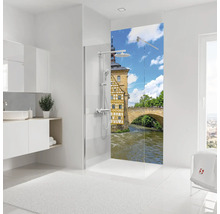 Salle de bains lumineuse avec douche à l'italienne, paroi décorative avec motif de ville historique et meuble sous lavabo.