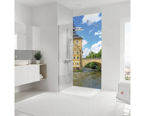 Salle de bains lumineuse avec douche à l'italienne, paroi décorative avec motif de ville historique et meuble sous lavabo.