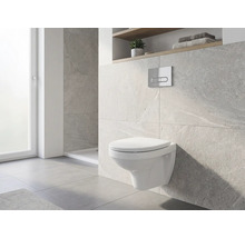 WC suspendu dans une salle de bains avec mur carrelé et fenêtre