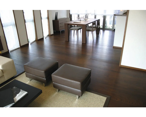 Parquet sombre dans un salon moderne avec coin repas, table en bois et poufs.