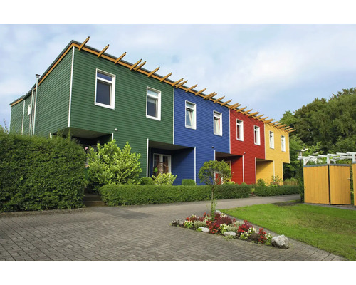 Maisons mitoyennes modernes avec des façades en bois colorées et un jardin aménagé avec des haies et des parterres de fleurs.