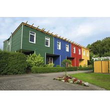 Maisons mitoyennes modernes avec des façades en bois colorées et un jardin aménagé avec des haies et des parterres de fleurs.