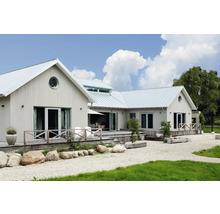 Maison moderne avec façade en bois verticale, grande terrasse en bois et jardin de gravier avec pierres naturelles.