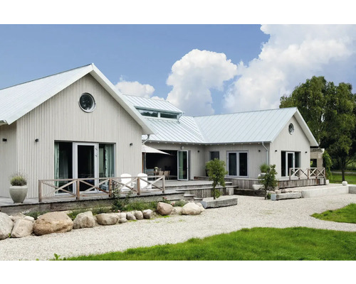 Maison moderne avec façade en bois verticale, grande terrasse en bois et jardin de gravier avec pierres naturelles.