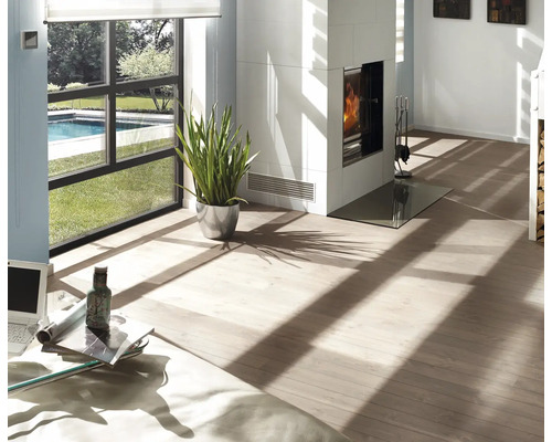 Revêtement de sol clair dans un salon moderne et lumineux avec cheminée blanche, plante d'intérieur et grande fenêtre vue sur piscine.