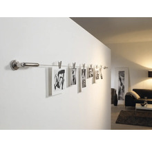 Photos sur une tringle murale avec des pinces dans le salon