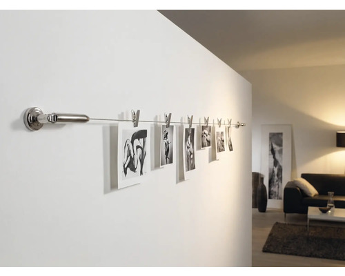 Photos sur une tringle murale avec des pinces dans le salon