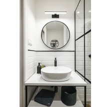 Salle de bains avec miroir rond, lavabo à poser et accents noirs