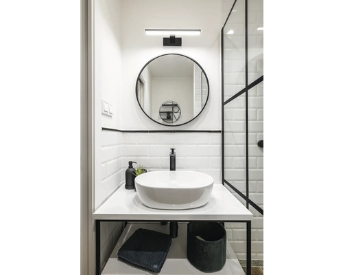 Salle de bains avec miroir rond, lavabo à poser et accents noirs