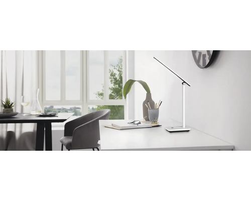 Tischleuchte auf einem Schreibtisch in einem hellen Raum.