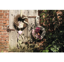 Couronnes décoratives en matériaux naturels sur une porte en bois