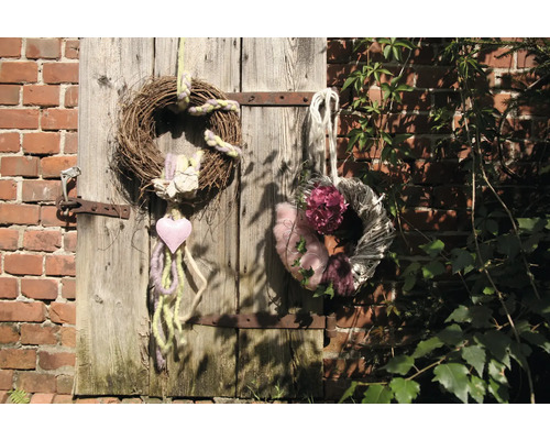 Couronnes décoratives en matériaux naturels sur une porte en bois