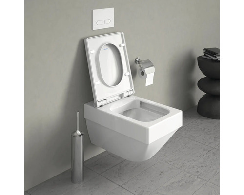 WC suspendu avec couvercle ouvert, plaque de commande, brosse de toilette et porte-papier hygiénique dans une salle de bains.