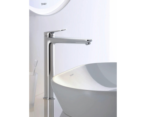 Duravit Waschtischarmatur aus Chrom mat héijem Auslaf nieft engem wäissen Opsatzwäschbecken an engem helle Buedzëmmer.