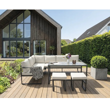 Ensemble de salon de jardin avec table et tabourets sur une terrasse en bois devant une maison
