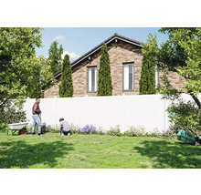 Gartenszene mit Personen, Rasen, Zaun und Haus im Hintergrund