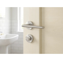 Tür mit Türbeschlag und Badezimmer im Hintergrund