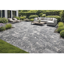 Terrasse mit grauen Terrassenplatten, Gartenmöbeln und Bepflanzung