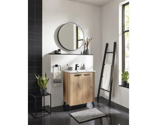Salle de bains moderne avec meuble sous lavabo en bois, lavabo blanc, robinet noir, miroir rond et échelle porte-serviettes noire.