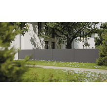 Clôture de jardin moderne grise à panneaux horizontaux dans un jardin lumineux avec une maison blanche et un grand arbre à l'arrière-plan.