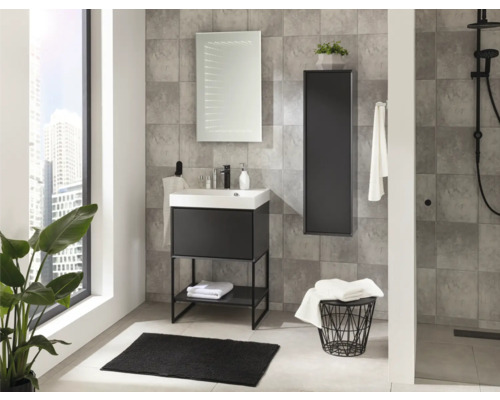 Salle de bain moderne avec meuble sous vasque noir, lavabo blanc, miroir LED et armoire murale noire sur carrelage gris. Clair et organisé.