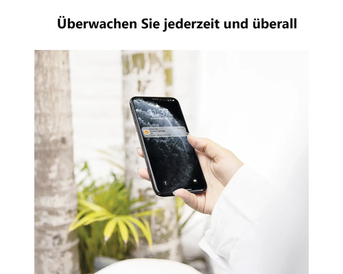 Smartphone avec une notification d'une application de maison connectée pour surveiller un thermostat sans fil à distance.