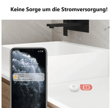 Détecteur de fuite d'eau Imou sur un lavabo avec une notification de batterie faible sur un smartphone.