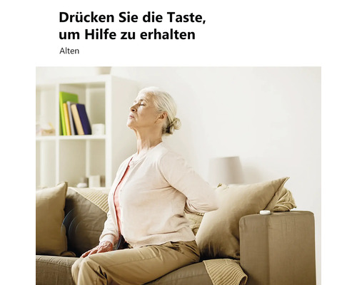 Ältere Frau mit Rückenschmerzen auf einem Sofa im hellen Wohnzimmer, neben einem Notfallknopf auf der Armlehne.