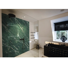 Salle de bains moderne avec panneau aspect marbre vert, robinetterie noire, paroi en verre et baignoire noire texturée.