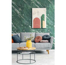 Salon moderne avec papier peint effet marbre vert, canapé gris avec coussins décoratifs et table basse ronde devant une œuvre d'art abstraite.