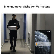 Personne avec cartons de livraison dans un couloir et smartphone avec notification de détection de rôdage par une caméra de sonnette.