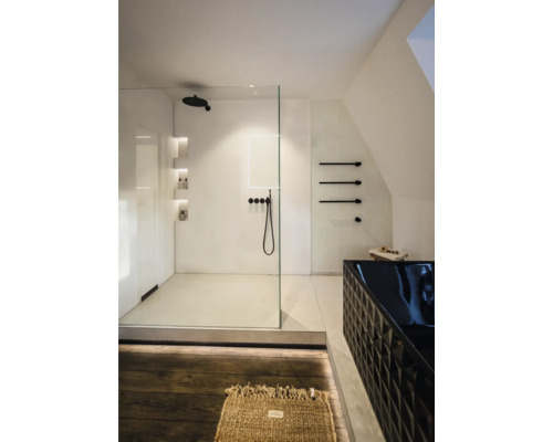 Salle de bains moderne et lumineuse avec douche à l'italienne en verre, robinetterie noire et baignoire noire texturée. Design minimaliste.