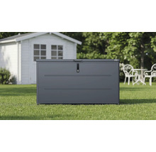 Coffre de jardin Weka en métal anthracite sur une pelouse devant un abri de jardin blanc.