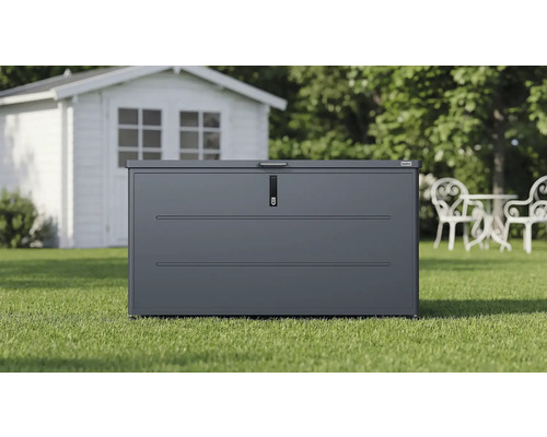 Coffre de jardin Weka en métal anthracite sur une pelouse devant un abri de jardin blanc.