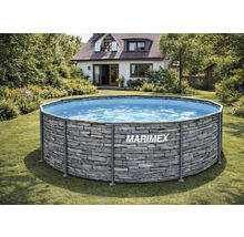 Piscine hors-sol Marimex avec paroi extérieure aspect pierre dans un jardin ensoleillé devant une maison.