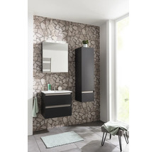 Ensemble de salle de bains moderne avec meuble sous-lavabo sombre, vasque, armoire de toilette et colonne devant un mur aspect pierre.