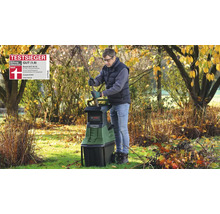 Homme utilisant le broyeur Bosch AXT 25 TC au jardin avec lunettes et gants. Sceau du vainqueur du test Stiftung Warentest.
