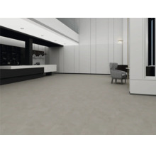 Intérieur spacieux et moderne avec un revêtement de sol gris à larges dalles, des murs à panneaux blancs et un design minimaliste.