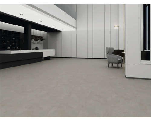 Intérieur spacieux et moderne avec un revêtement de sol gris à larges dalles, des murs à panneaux blancs et un design minimaliste.