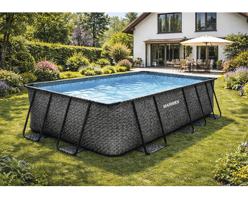 Rechteckiger Marimex Frame Pool mit Rattan-Optik auf einer Rasenfläche in einem Garten mit Blumen und Hecken.