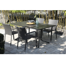 Ensemble de jardin avec une table rectangulaire et quatre chaises en rotin synthétique sur une terrasse pavée devant des bambous.