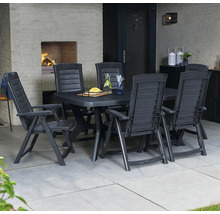 Salon de jardin en plastique foncé avec table rectangulaire et chaises à dossier haut sur une terrasse avec cheminée et sol carrelé.