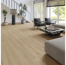 Salon lumineux avec revêtement de sol aspect chêne, fauteuils gris, table basse en marbre et grandes fenêtres.
