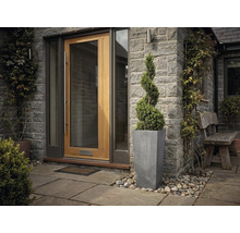 Moderner Hauseingang mit Holz-Haustür, Natursteinwand, hohem Pflanzgefäß und spiralförmig geschnittenem Buchsbaum.