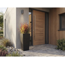 Hoher, quadratisch-konischer Pflanzkübel in Schwarz vor einer modernen Holzhaustür mit langem Griff und Pflastersteinen.