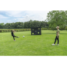 Enfants jouant au football dans un jardin avec un but de football et une paroi de tir sur une pelouse.