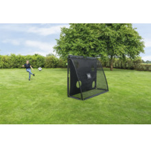 Une fille joue au football avec un filet de rebond EXIT Toys noir doté d une paroi de tir dans un jardin.