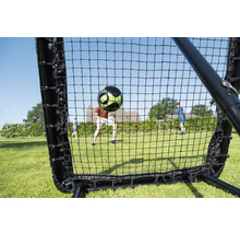 Fußball Rebounder Netz am Gaart mat engem fliegenden Fußball a spillenden Persounen op enger Wiss.